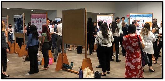 Students presenting research at a conference in HUB 302